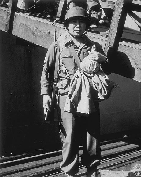 S/Sgt. Hideo Noyama, 30105110, Honolulu, a member of the 442nd Infantry Regiment is shown on pier 2 before embarking on HR-218 for overseas service. Seventy-five percent of this regiment were born in Hawaii of Japanese ancestry.